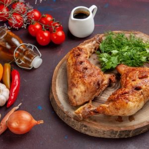 top-view-delicious-fried-chicken-with-fresh-vegetables-greens-dark-desk